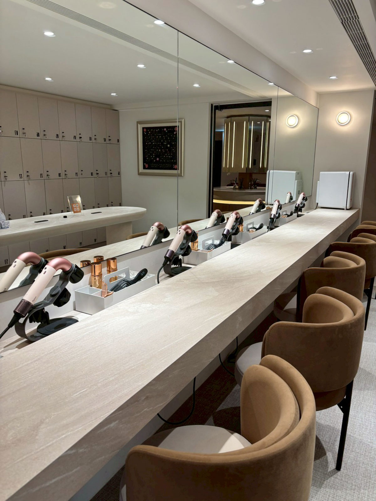 美力時尚診所 忠孝旗艦店梳化區，一排 Dyson 吹風機與高品質的化妝椅